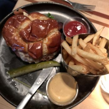 Root Down DIA - His burger on a pretzel bun with regular fries. - New American Near Me - Denver, Colorado