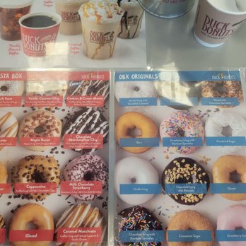 Duck Donuts - A menu board shows a selection of donuts and coffee beverages at Duck Donuts, including glazed, cinnamon sugar, and specialty flavors, with coffee cups and drinks visible above. - Donuts Near Me - Moosic, Pennsylvania