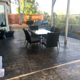 New, stamped patio with view of new decking around tree and gas fire pit in the far right corner.