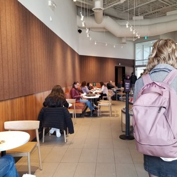 Starbucks - a woman with a backpack walking through a cafeteria - Coffee & Tea Near Me - Mississauga, Ontario Starbucks - a woman with a backpack walking through a cafeteria - Coffee & Tea Near Me - Mississauga, Ontario