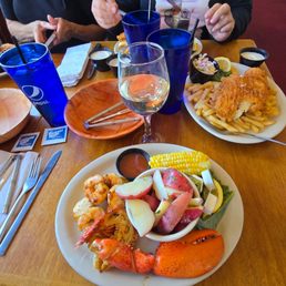 The seafood grill consists of half a lobster, 4 scallops, 4 shrimp,  corn, and potatoes.