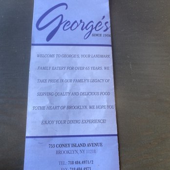 George's - Menu - A vertically oriented paper document from George's restaurant in Brooklyn, NY, displaying the restaurant's name, address, and contact details. The document includes a welcome message emphasizing the restaurant's long history and dedication to quality food, along with the website URL. The paper appears slightly crumpled and is placed on a dark surface. - Diners Near Me - Brooklyn, New York