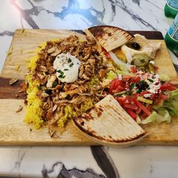 Chicken shwarma plate with hummus saffron rice salad and warm pita. Chicken shwarma plate with hummus saffron rice salad and warm pita.