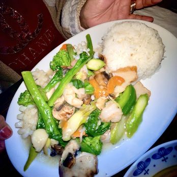 Noodles - Seafood delight - A white plate holds a serving of steamed rice alongside a vegetable and seafood stir-fry, including broccoli, mushrooms, and shrimp. - Chinese Near Me - Pala, California