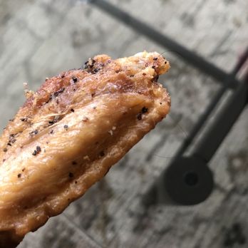 Wingstop - a hand holding a piece of food - Chicken Wings Near Me - Everett, Washington