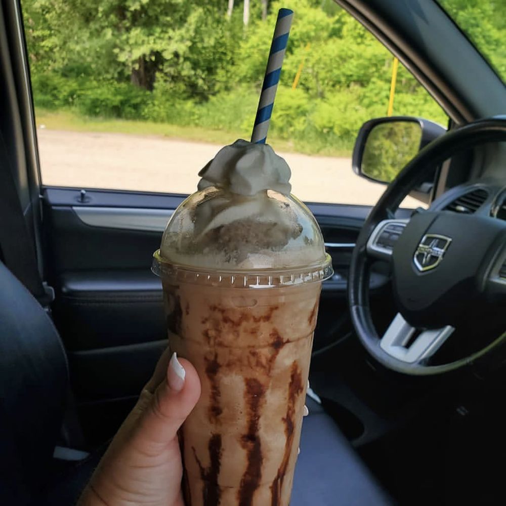 Brew Há - a hand holding a drink in a car - Coffee & Tea Near Me - Mesick, Michigan Brew Há - a hand holding a drink in a car - Coffee & Tea Near Me - Mesick, Michigan