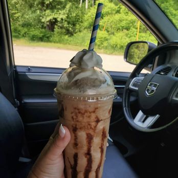Brew Há - a hand holding a drink in a car - Coffee & Tea Near Me - Mesick, Michigan
