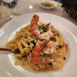 Full plate of lobster penne pasta in cream sauce with 2 large prawn