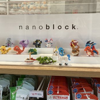 Miniso - LEGO-style pixel art figures of Pokémon characters are displayed on a white shelf at Nanoblock, with packaging and price tags visible below. - Department Stores Near Me - Pasadena, California