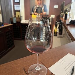 a glass of wine on a table a glass of wine on a table