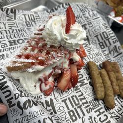 Brunchology - Belgian waffle w/strawberries, whipped cream and pork sausage.