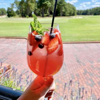 The Deuce - a hand holding a glass of fruity drink - New American Near Me - Pinehurst, North Carolina
