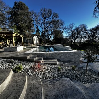 Clear Cut Landscaping - a pool surrounded by stone steps - Irrigation Near Me