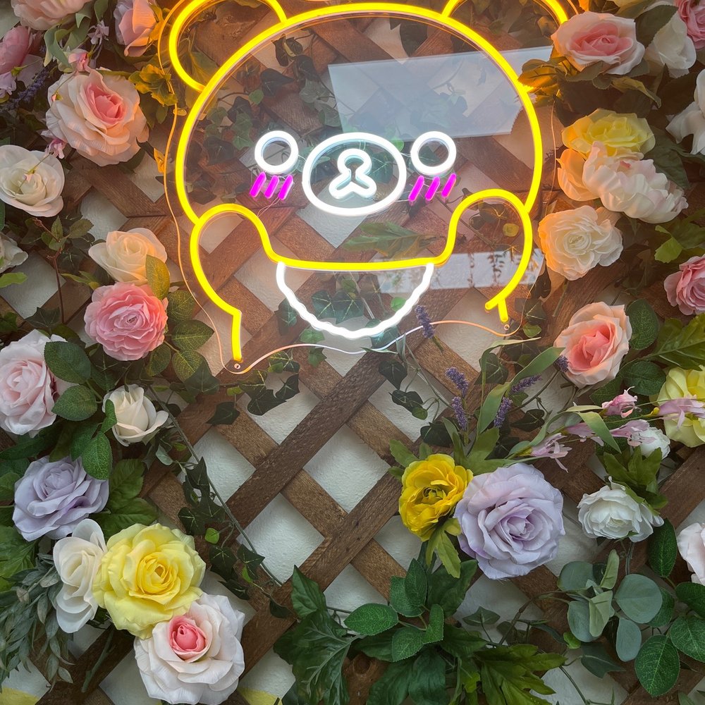 The Butter Bear - a neon sign with flowers in the background - Bakeries Near Me - Palmview, Texas The Butter Bear - a neon sign with flowers in the background - Bakeries Near Me - Palmview, Texas