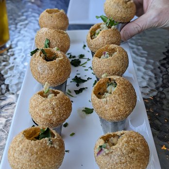 Parivaar Pub - Pani Puri. Potato, onion, spices stuffed into crispy puri. Topped with tamarind chutney. Served with pani (water), tamarind & mint. - Indian Near Me - Buffalo, New York