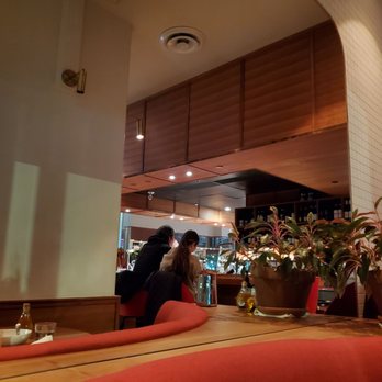 Nook - a woman sitting at a table in a restaurant - Pizza Near Me - Vancouver, British Columbia