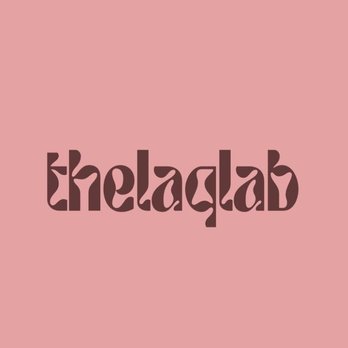 Thelaqlab - The image features a logo with the word 'thelaqlab' written in a unique, stylized font in dark brown color. The background is a solid light pink, creating a contrast that highlights the text. The design is simple and centered, with no additional elements or imagery. - Nail Salons Near Me - Brooklyn, New York