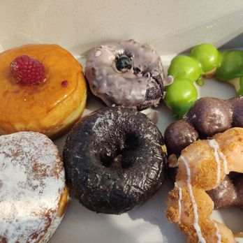 Friendly Donuts - Powdered Donut with lemon filling Creme Brulee Donut Ube Donut with Blueberry glaze Ube Donut Green Thai Tea Donut Ube Mochi Donut - Donuts Near Me - Orange, California