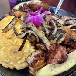 Colombia Parce - Picada: fried plantains, yucca fries, Colombian pork belly & sausage, charred fried onions, and a sliced avocado.