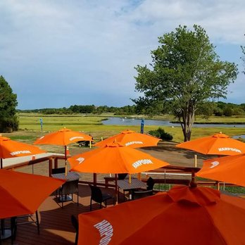 Riversbend - tables and umbrellas on a deck overlooking a lake - Pizza Near Me - Essex, Massachusetts