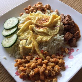 Bali Kitchen - Nasi kuning: coconut rice topped with scrambled egg and served with spicy rendang beef, tempeh oreh, anchovies and peanuts. - Indonesian Near Me - Sacramento, California