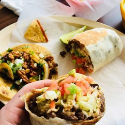 a hand holding a burrito