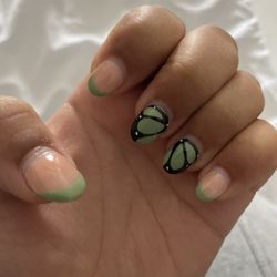 V Nails & Spa - It's an acrylic set with gel polish and a simple green French tip with two fingers looking like the wings of a butterfly.