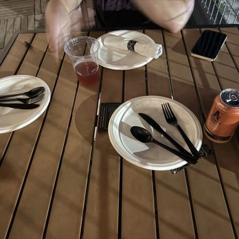Downtown By Chef Jay Pisculli - The paper plates, plastic utensils and glasses on the simple wooden tables. - Lounges Near Me - Binghamton, New York