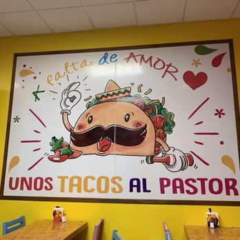Perico's Fast Tacos - a taco with a mustache - A mural on a yellow wall depicts a cartoon taco with a mustache, sombrero, and salsa, surrounded by hearts and decorative elements, with text in Spanish and English. - Tacos Near Me - Peoria, Illinois