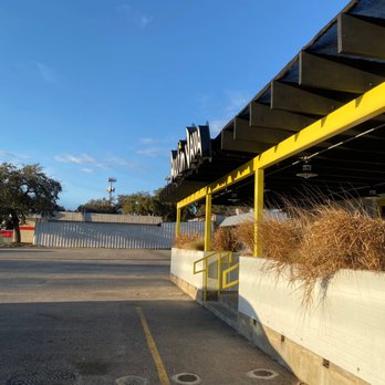 Austin Java - a parking lot with a yellow awning - Coffee & Tea Near Me - Austin, Texas