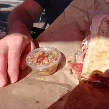 Square Onion - a person holding a sandwich and a cup of salsa - Specialty Food Near Me - Mount Pleasant, South Carolina Square Onion - a person holding a sandwich and a cup of salsa - Specialty Food Near Me - Mount Pleasant, South Carolina