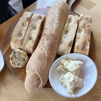 Saluti - Baked bread board. Garlic butter. Highlight here is the half bulb of roasted garlic. Scoop and spread. Two kinds of bread. - Italian Near Me - Lake George, New York Saluti - Baked bread board. Garlic butter. Highlight here is the half bulb of roasted garlic. Scoop and spread. Two kinds of bread. - Italian Near Me - Lake George, New York