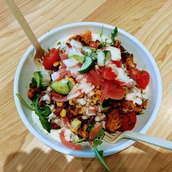 CAVA - a bowl of food on a wooden table - Mediterranean Near Me - Raleigh, North Carolina