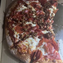 Partly eaten large double pepp and sausage pizza