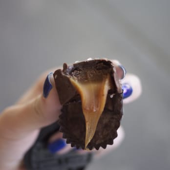 Purdys Chocolatier - a hand holding a piece of chocolate - Ice Cream & Frozen Yogurt Near Me - Vancouver, British Columbia