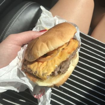 Wendy's - a hand holding a cheeseburger - Burgers Near Me - Nanuet, New York