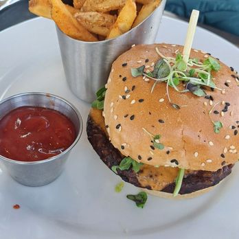 Summit Restaurant - Lookout Burger Bean patty on a sesame seed brioche with Canadian cheddar, edemame hummus, tomato jam & dill pickle. - American Near Me