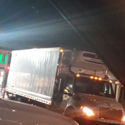 7-Eleven - This is the delivery truck in reference to and off to the left of the truck you can see a red little Pole that's where the entrance is at
