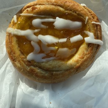 Abbate Bakery - A pastry with a golden-brown crust, topped with white icing and caramel sauce, placed on parchment paper. - Bakeries Near Me - Matawan, New Jersey