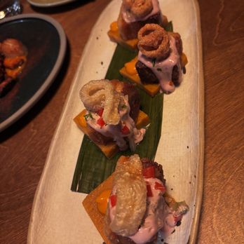 Suyo Modern Peruvian - PORK BELLY CHICHARRON roasted yam puree, salsa criolla, polenta tamal, olive emulsion - Peruvian Near Me - Vancouver, British Columbia
