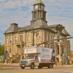 Millersburg Electric - A branded delivery truck for Millersburg Electric is parked in front of a historic courthouse building...