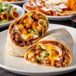 Fuego Cravings - Loaded, cheesy, and packed with flavor! This hearty breakfast burrito is filled with savory meat, crispy potatoes, eggs, melted cheese.