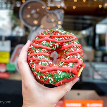 Randy's Donuts - a hand holding a doughnut with sprinkles - Donuts Near Me - Pasadena, California
