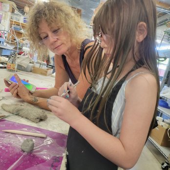 Lively Mind Art Studio - Tosca guiding Zoey - A woman and a girl are engaged in a clay art activity at a studio, with tools and clay on the table, surrounded by art supplies. - Arts & Crafts Near Me - Phoenix, Arizona
