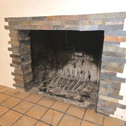 Dyxon Designs and Services - Replaced the crumbling tile around this fireplace with slate tile.