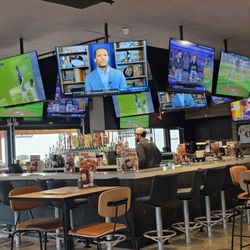 Buffalo Wild Wings - The bar of the restaurant with many large screen TVs all around, high above.