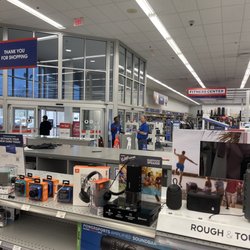 Academy Sports + Outdoors - Front of store with 3 employees talking while long line continues