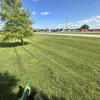 Will Cuts Grass - a lawn mower in the foreground - Lawn Services Near Me