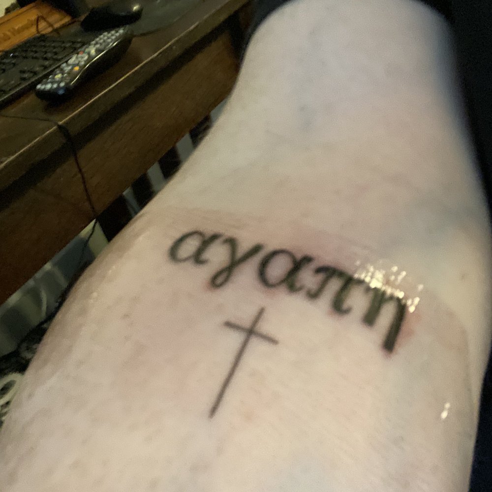 My tattoo says Agape in Greek lettering with a small cross below it. My tattoo says Agape in Greek lettering with a small cross below it.