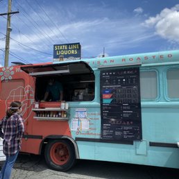 a man standing in front of a food truck a man standing in front of a food truck